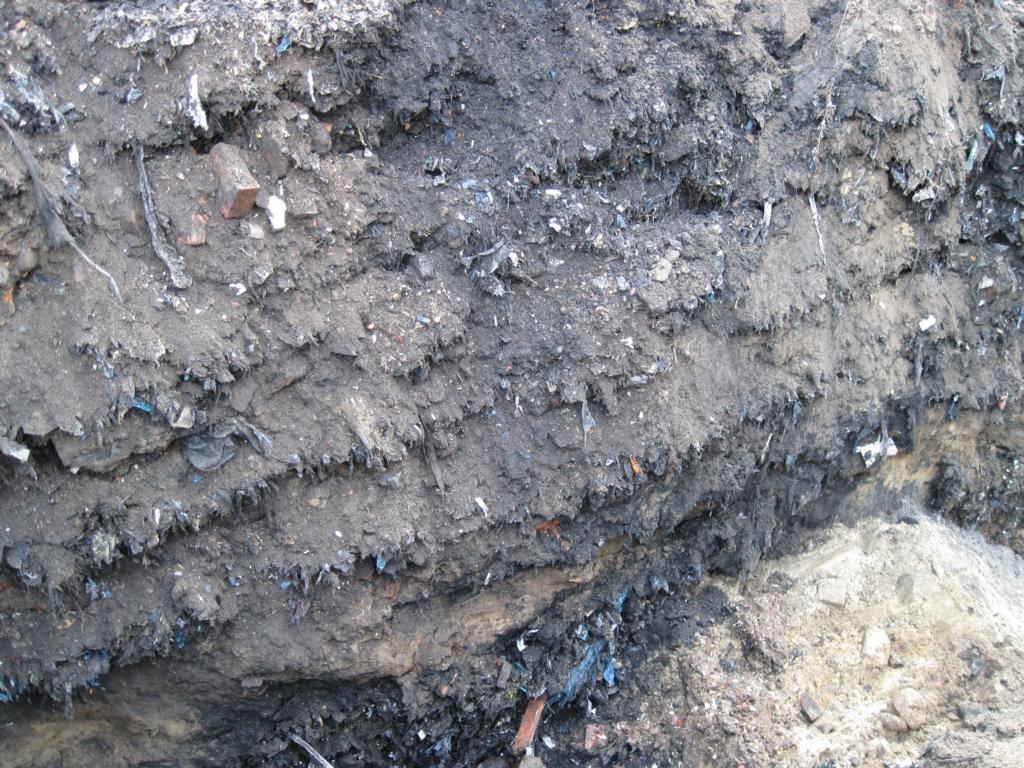 Beispiel einer feinen Wechsellagerung von Abfällen und Sand in den oberen Schichten